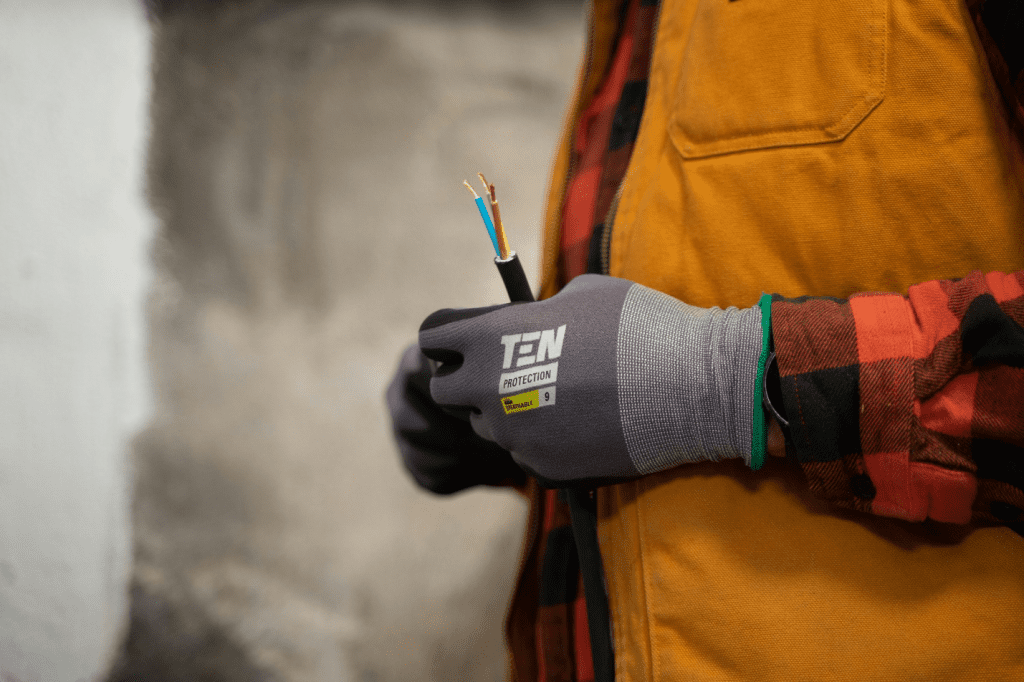 Electrician holding exposed wiring while performing residential electrical troubleshooting and repair work