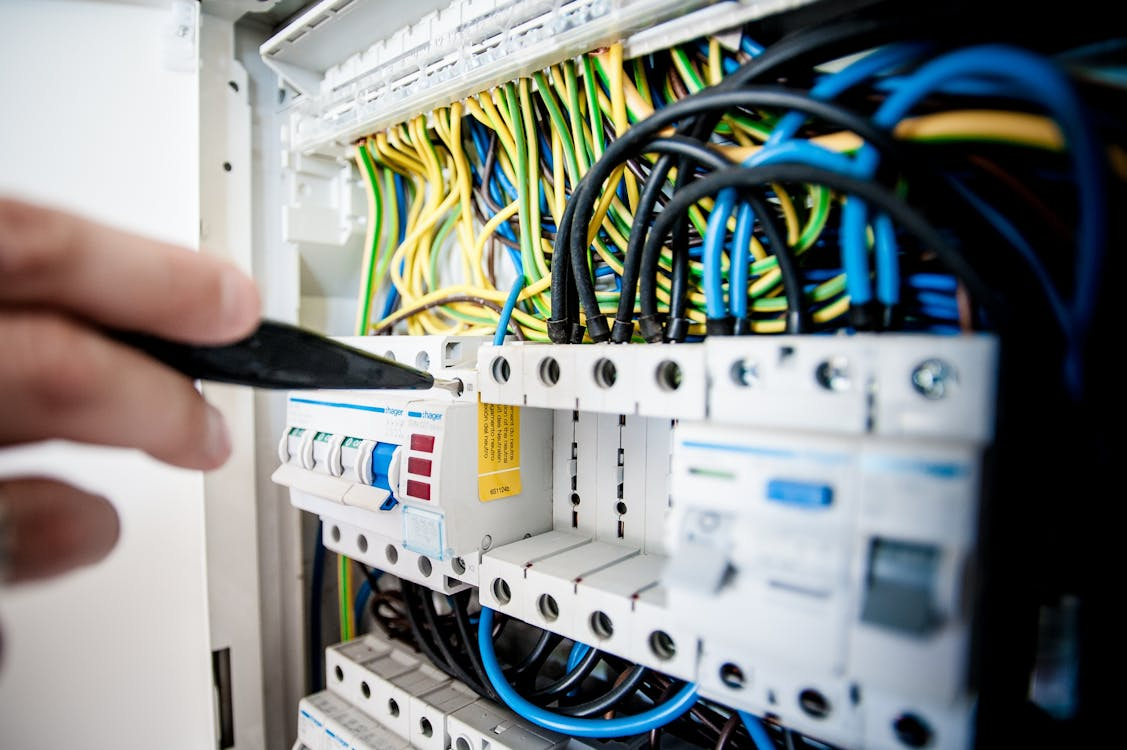 Electrician inspecting a dedicated electrical circuit panel for a residential hot tub installation