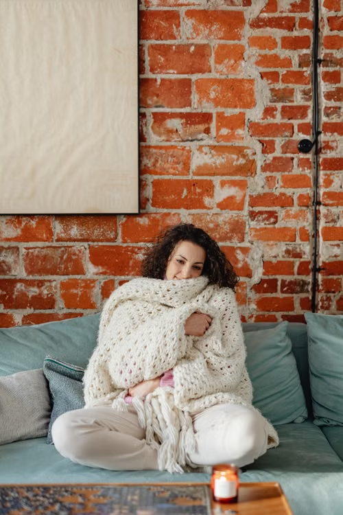 A woman cozy inside her home.