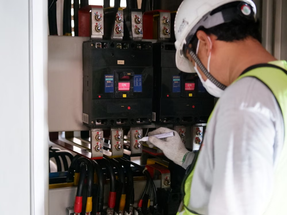 An electrician checking a circuit breaker